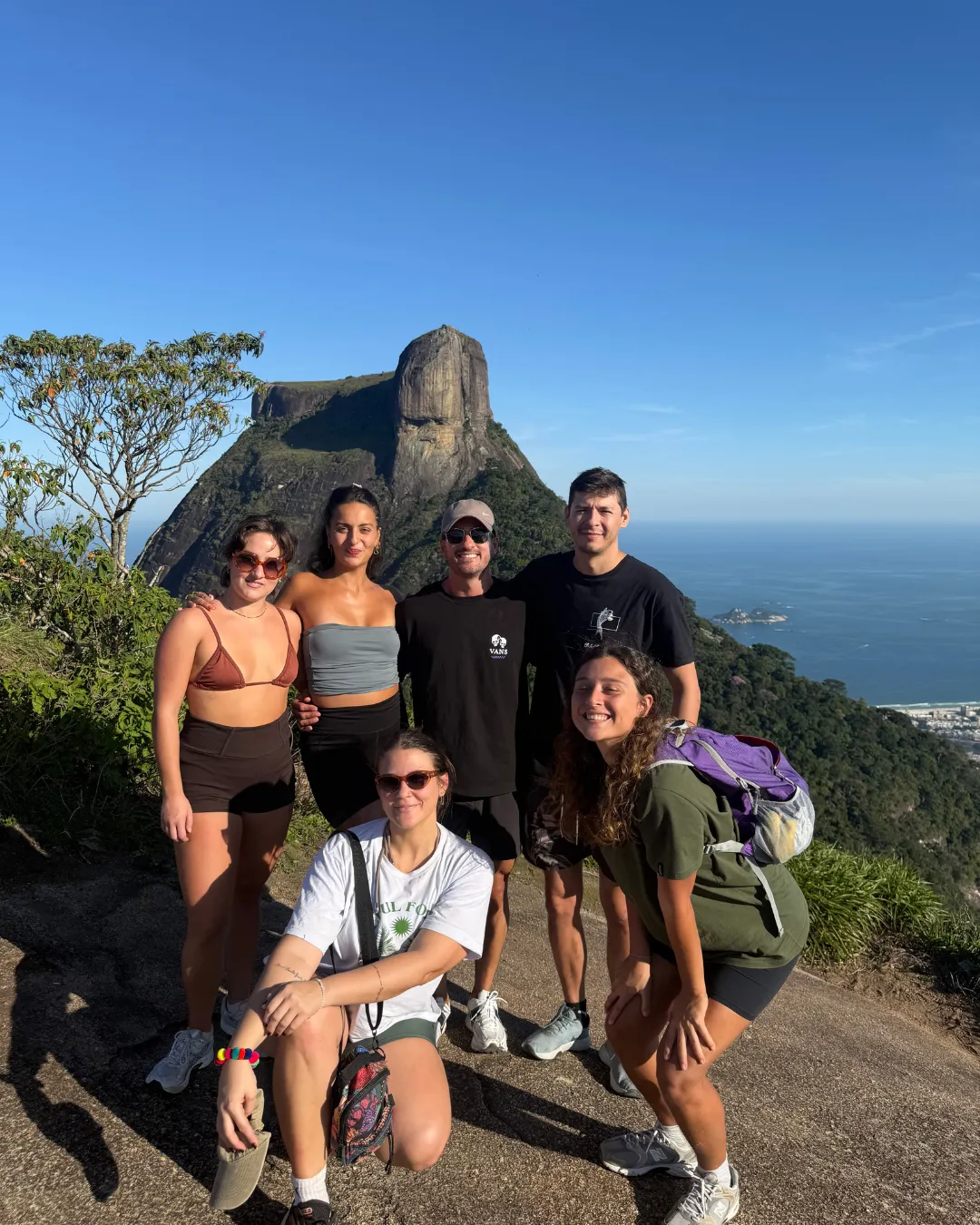 A ConvoLab group on a hike above Rio de Janeiro, with Pedra da Gávea and the sea behind them