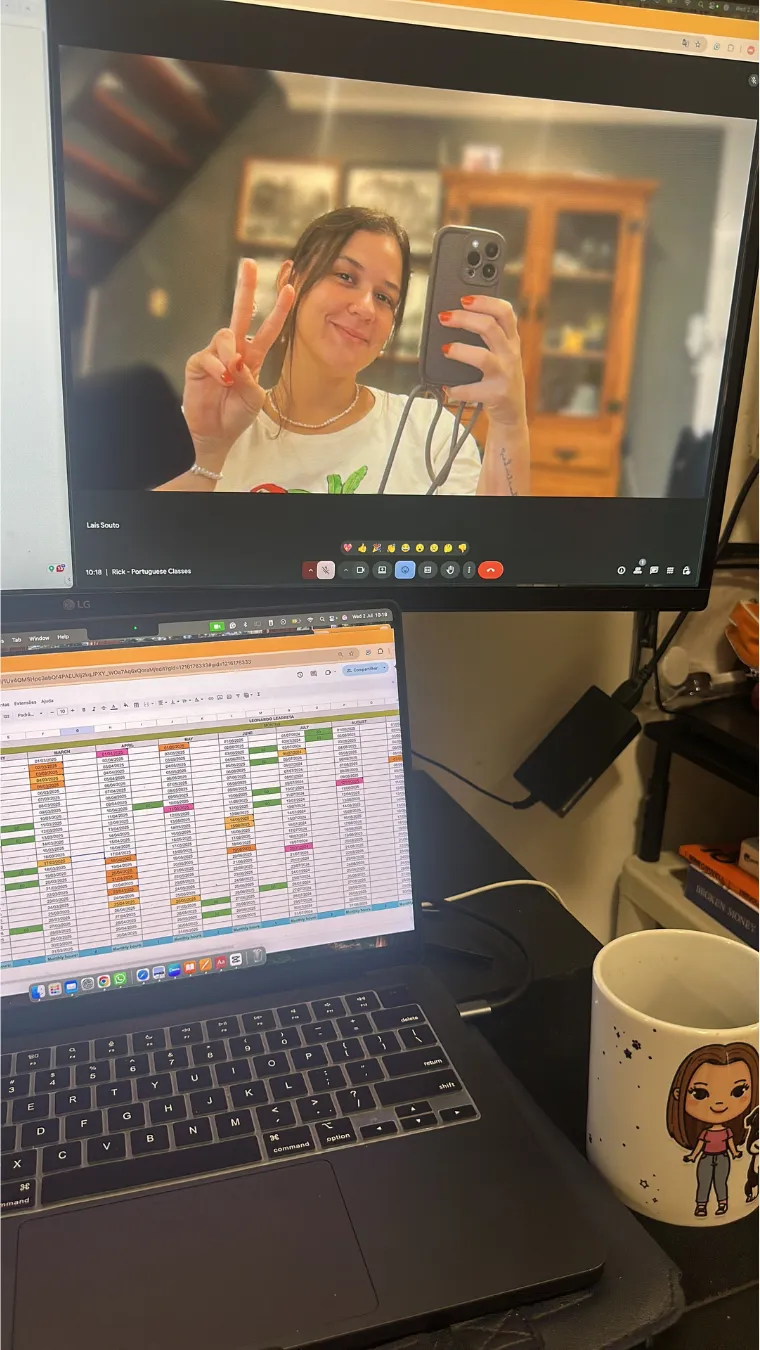Laís making a peace sign on a video call, with her lesson spreadsheet open on the laptop below